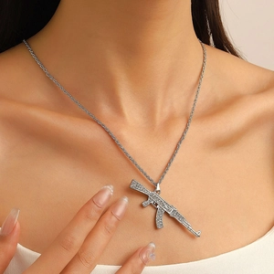 Close-up of a silver AK-47 pendant necklace with rhinestones on a twist chain
