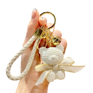 Cute white resin sitting bear keychain with knitted texture and beige braided strap