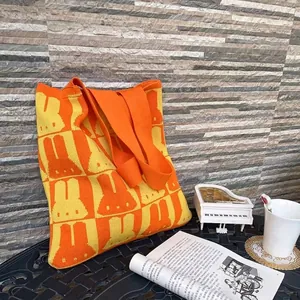 Checkered knit tote bag with rabbit silhouette pattern in vibrant yellow and orange