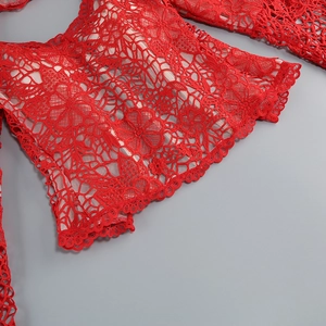 Gros plan sur la dentelle florale rouge avec motifs ajourés et bords ondulés