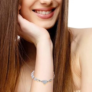 Close-up of a silver heart-shaped magnetic clasp with rhinestones on a pearl bracelet