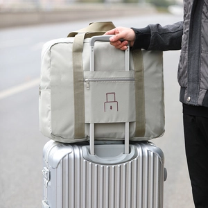 Foldable oxford travel bag in gray and olive green mounted on a suitcase handle
