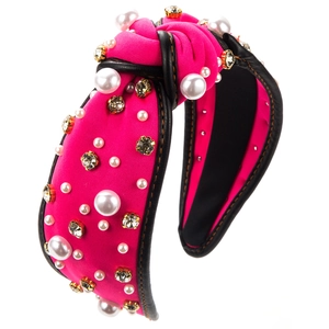 Détail du serre-tête noué rose avec perles, cristaux et bord en similicuir noir