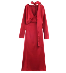 Détail de la robe en satin rouge avec décolleté en V et élégants rubans en écharpe