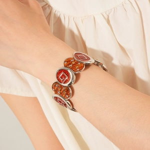 Gros plan du bracelet étoile en émail vintage avec maillons rouges et orange