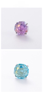 Macro shot of iridescent octagon cut zircon studs in purple and blue with four-prong setting