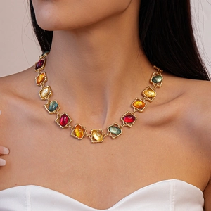Close-up of vintage gold necklace with colorful resin stones on a model's neck
