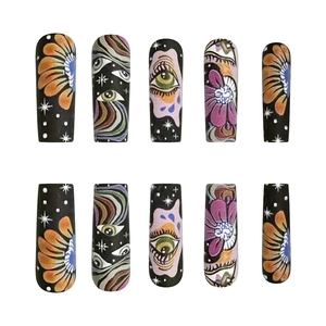 Extra long black press-on nails with colorful eye patterns and floral art designs