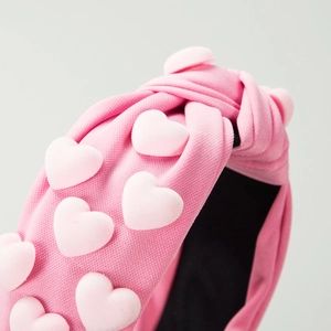 Pink fabric knotted headband with 3D heart charms and non-slip lining for women