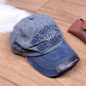 Close-up of vintage washed baseball cap featuring patch embroidery and leather edge trim