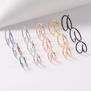 Close-up of spiral double nose rings in silver, gold, rose gold, black and rainbow finishes