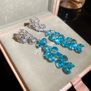 Gros plan de boucles d'oreilles papillon en cristal bleu ciel avec de longs glands
