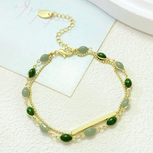 Dettaglio bracciale doppio strato placcato oro con perline verdi e catena regolabile