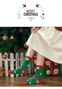 Detailed view of green Christmas socks with Santa Claus pattern and holiday decorations