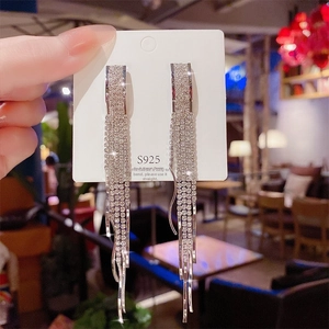 Close-up of long tassel earrings with silver 925 needles and sparkling zircon stones