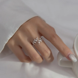 Silver olive branch open ring with sparkling cubic zirconia on a model hand