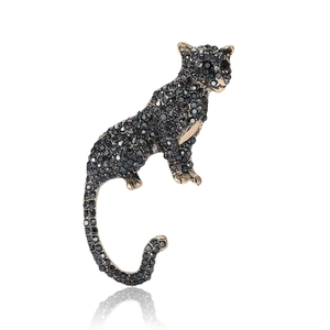 Vintage gold leopard brooch with black rhinestones shown from a front-facing studio view