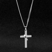Macro shot of silver layered cross pendant with diagonal ring and fine curb chain link