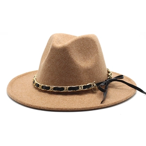 Detail of camel wool fedora hat featuring a gold chain and black leather decorative band