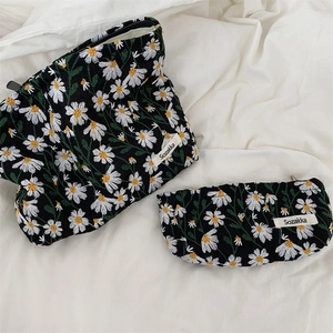 Close-up of daisy embroidery on black durable fabric cosmetic bags with Sozakka tag