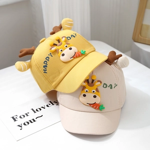 Detail of yellow and beige baby baseball hats with cute giraffe and happy day text