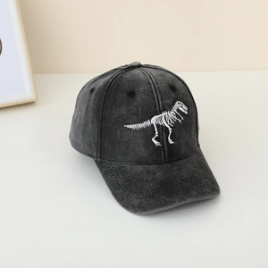 Dettaglio del ricamo di dinosauro bianco su cappellino vintage grigio per bambini