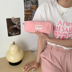 Detailed close-up of a pink macaron storage bag held by a model in a cozy scene