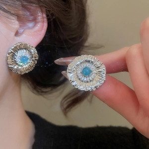 Close-up of vintage flower earrings with blue stone and sparkling zircon details