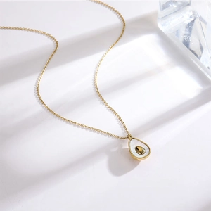 Détail du pendentif avocat doré 18 carats avec incrustation en nacre blanche élégante