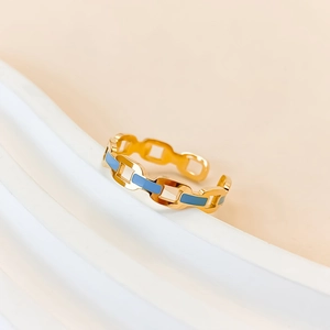 Detailed view of gold link ring with light blue enamel inlay and open adjustable design
