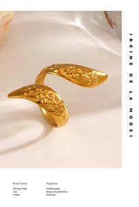 Close-up of golden vintage-style ring featuring embossed floral patterns and leaf details