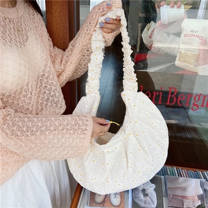 Detail of white daisy print canvas shoulder bag with ruffled strap and yellow zipper