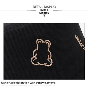 Close-up of golden bear embroidery and unique lettering on black cotton bucket hat