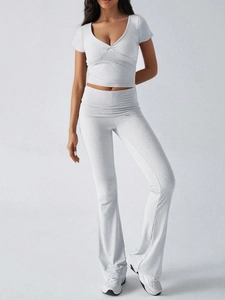 Vue détaillée du crop top blanc à col en V et du pantalon évasé à taille haute