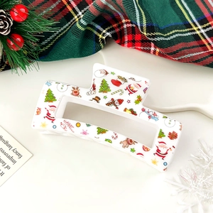 Detail of white Christmas hair claw clip with festive elk and Santa prints on red plaid