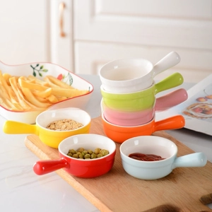 Close-up of colorful heart-shaped ceramic dip bowls with handles on a wooden board
