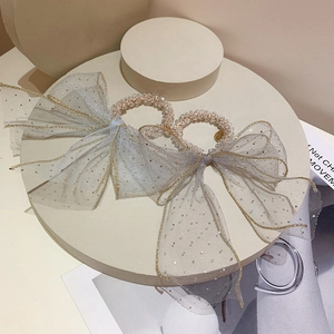 Close-up of beaded hair ties with gray-blue mesh bow and golden sequin detailing