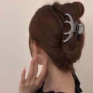 Large silver metal hair claw clip for women, shown on hair in an elegant updo hairstyle