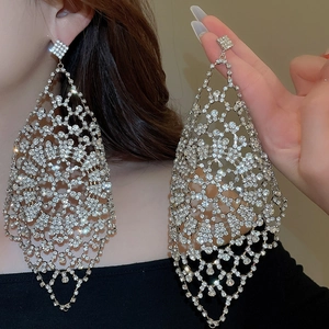 Macro detail of oversized sparkling rhinestone fringe earrings with mesh hollow design