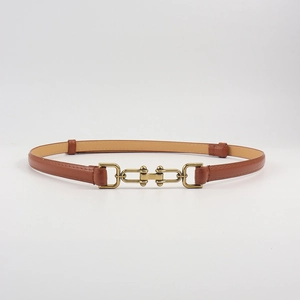 Detail view of brown leather belt featuring a vintage gold U-shaped metal buckle and loops