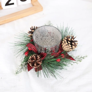 Macro of Christmas candle holder with red black buffalo plaid bow and pine cones