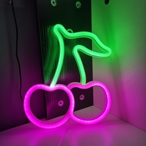 Pink and green LED cherry neon sign glowing on a black wooden background for wall decor