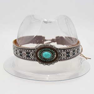 Detail of bohemian hat band featuring turquoise stone and ethnic embroidery patterns