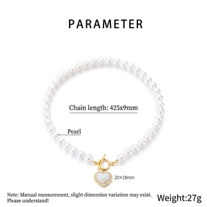Detail of white pearl necklace with golden heart pendant and T-bar toggle clasp