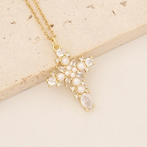 Detail of 18K gold-plated cross necklace with inlaid pearls and sparkling cubic zirconia