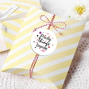 Striped gift pillow box with Pretty Things Inside sticker and decorative red cotton string