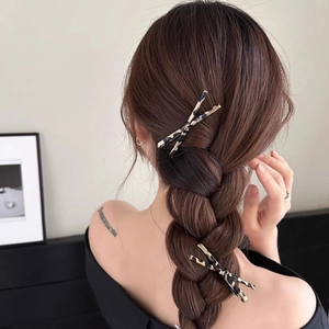 Set of two leopard print bow hair clips shown on model for elegant side hair styling