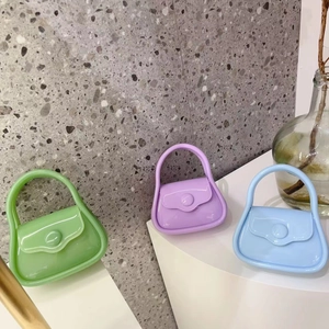 Mini macaron jelly handbags in green, purple, and blue colors on marble surface