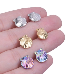 Detailed macro of small shell-shaped 304 stainless steel stud earrings in three metallic colors