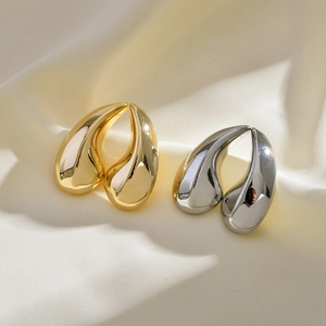 Polished waterdrop earrings in gold and silver finish on elegant silk background